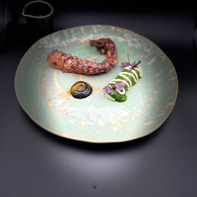 Tentacule de poulpe croustillante, poireau, sauce vigneronne encre de seiche